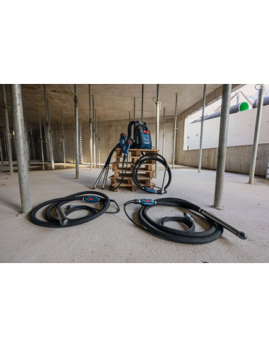 Gradbišče z dvema vibratorjema za beton in nahrbtnim napajalnikom na paleti.