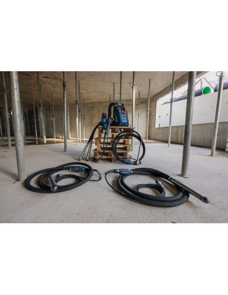Gradbišče z dvema vibratorjema za beton in nahrbtnim napajalnikom na paleti.